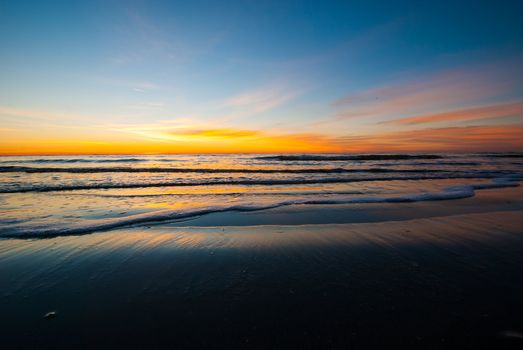 Photogrpah of a sunrise before the sun crests the horizon of a Saint Simons Island Beach.