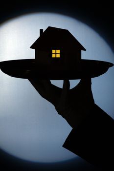 silhouette of a model of house on the tray. Real estate concept