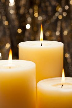 Candles in front of a gold glitter background