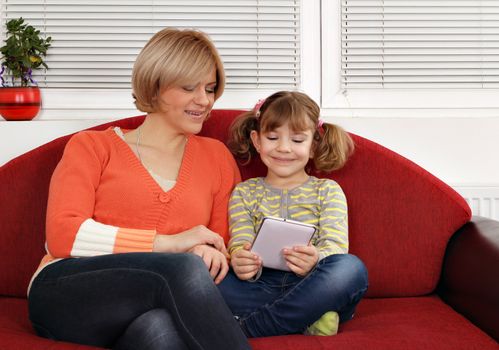 mother and daughter play with tablet pc family scene