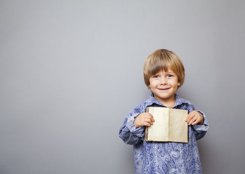 little boy holding an open book