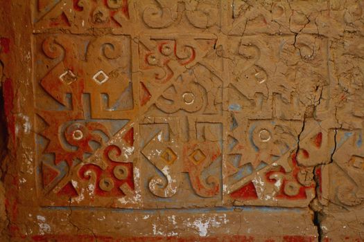 Painted and carved adobe wall in Huaca de la Luna, archaeological site in the Moche valley, Peru
