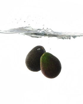 Avocadoes Making a splash while falling into clear water