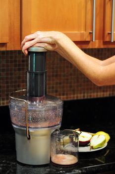 Woman Making apple and pear fruit juice in juicer