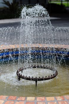 Pretty water fountain in garden in summertime