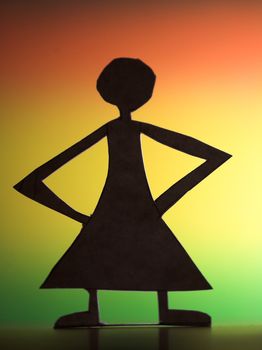 woman silhouette cut in small rudimentary figures  in paper , shot with colorfull background