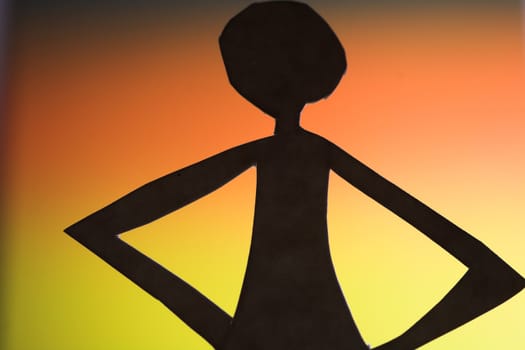 woman silhouette cut in small rudimentary figures  in paper , shot with colorfull background