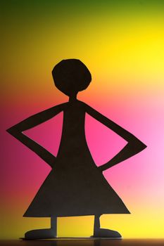 woman silhouette cut in small rudimentary figures  in paper , shot with colorfull background