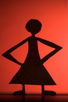 woman silhouette cut in small rudimentary figures  in paper , shot with colorfull background