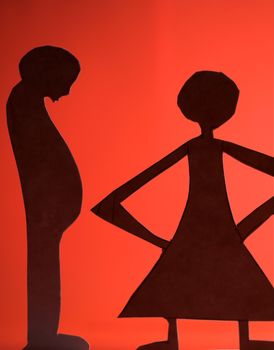 man and woman silhouette cut in small rudimentary figures  in paper , shot with colorfull background