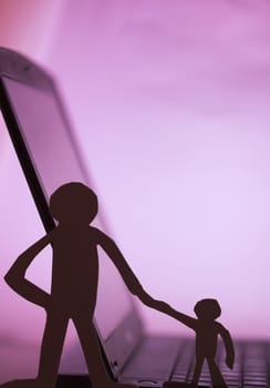father and son  silhouette cut in small rudimentary figures  in paper , man holding child hand facing a computer

