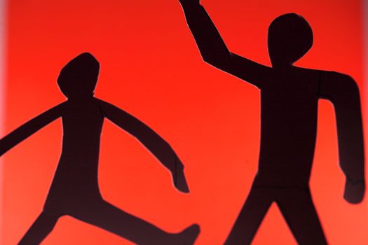 people silhouette cut in small rudimentary figures  in paper , shot with colorfull background