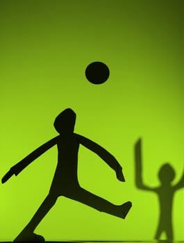 people silhouette cut in small rudimentary figures  in paper , shot with colorfull background
