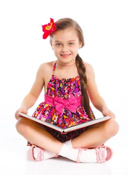 Happy cute girl sitting with book, isolated over white