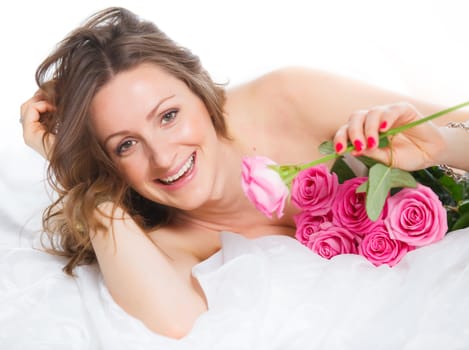 Beautiful young woman smelling a bunch of fresh roses