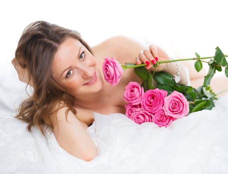 Beautiful young woman smelling a bunch of fresh roses