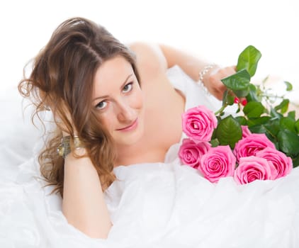 Beautiful young woman smelling a bunch of fresh roses