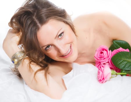 Beautiful young woman smelling a bunch of fresh roses