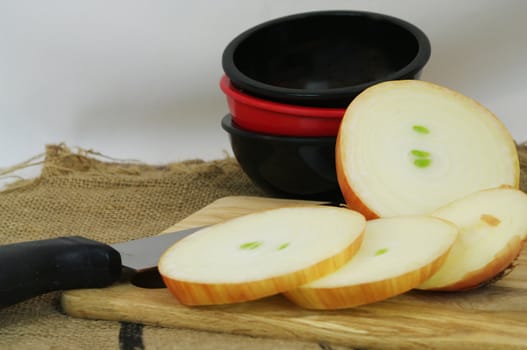 Onions Sliced on a cutting board with a knife and bowls