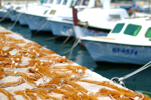 Fishing nets on shore and boats in background