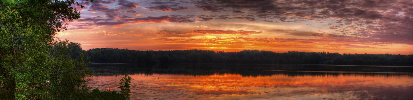 Panorama of a sunrise on a lake.