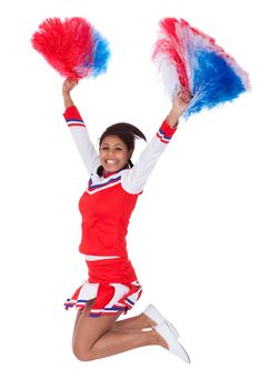 Smiling beautiful cheerleader with pompoms. Isolated on white