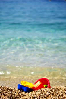 Children beach toys on the pebbles beach