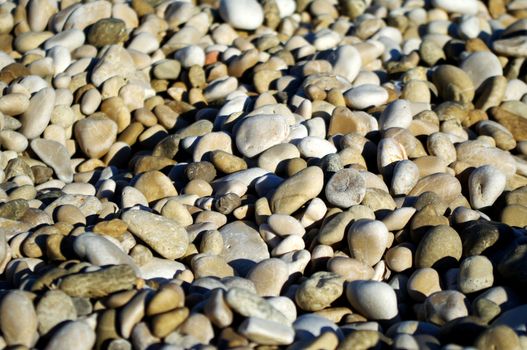 Sea pebbles background on sunny day