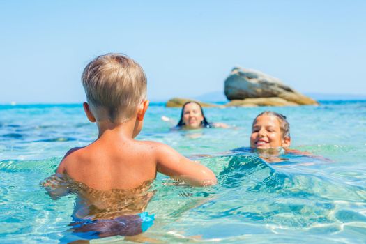 Happy kids. Sister and brother playing and swimming in the transparent sea