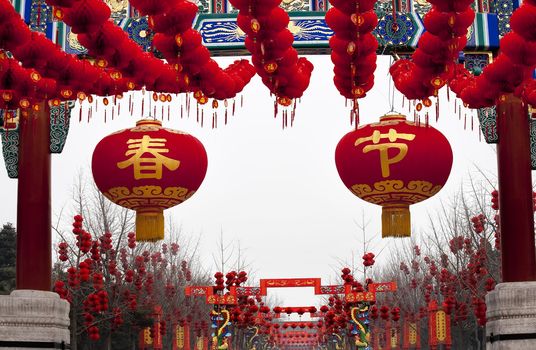 Large Spring Festival Lanterns,Lucky Red Lanterns Chinese New Year Decorations Gate Ditan Park Beijing China.  During Lunar New Year, many parks and temples in China have large outdoor fairs, festivals.  Chinese characters on lanterns say Spring Festival,  lucky and long life.