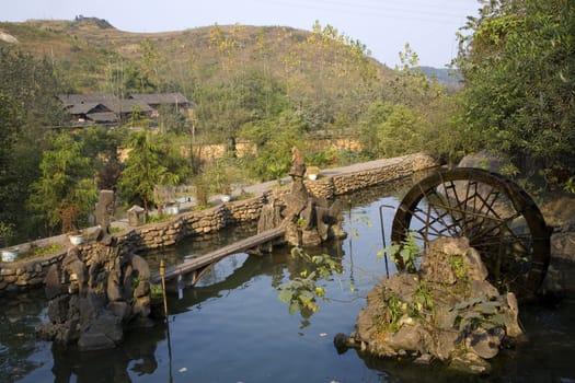 Pond and Garden with Wheel in front of village in countryside, Guizhou, China