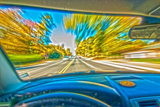 blured autumn and colored treelines visible from inside of car while driving