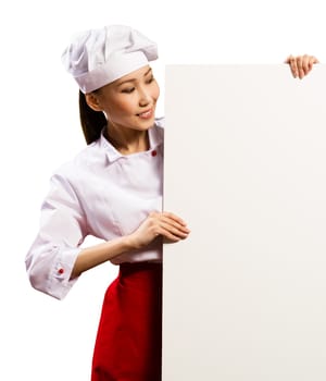 female chef holding a poster for text, look at the poster and smiling