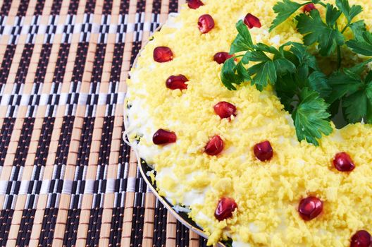 Salad with boiled egg, cream sauce and pomegranate seeds on a plate