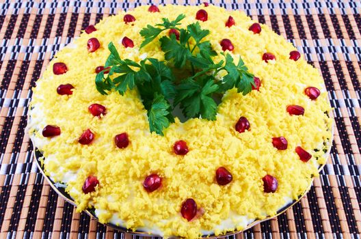 Salad with boiled egg, cream sauce and pomegranate seeds on a plate