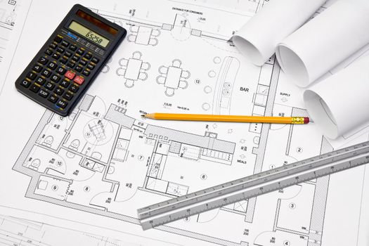 Calculator, scale ruler and pencil on architectural drawing blueprint