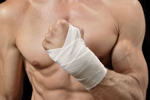 Closeup of shirtless man with fist wrapped in sports wrap