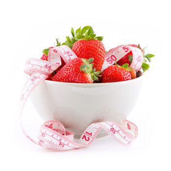 Fresh strawberries in a bowl with measure tape isolated