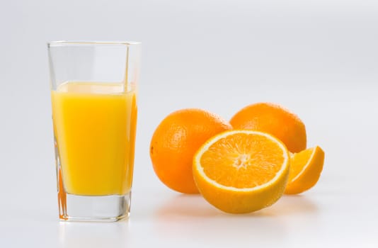 Orange juice and oranges on white background