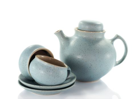 two crockery teacups and teapot on white