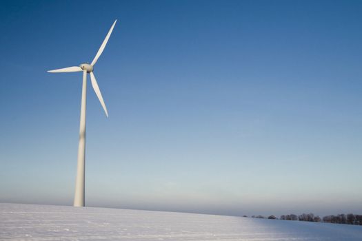 Windmill on a blue sky in winter, alternative energy source