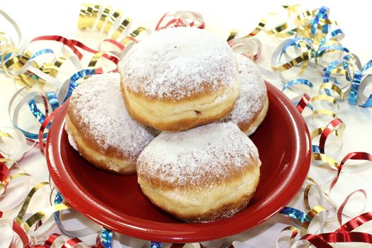 Pancakes with powdered sugar and jam on a plate with paper streamers