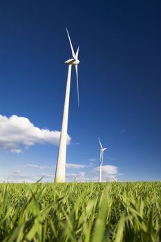 Windmills against a blue sky and clouds, alternative energy source