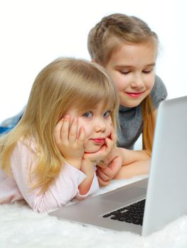 Portrait of a happy young girls with laptop computer. Vertical view. Isolated over white background