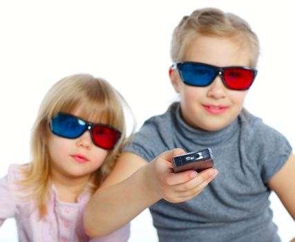 Studio shot of two girls in 3d glasses with control panel watching TV. Focus on the control panel. Isolated white background