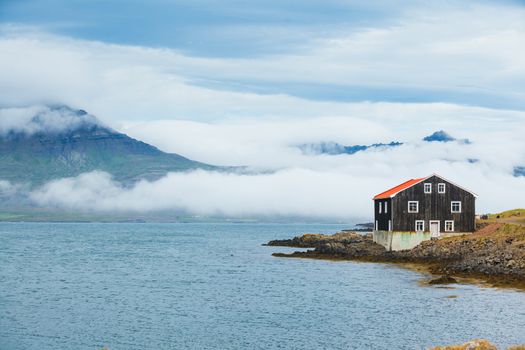 Rural beautiful summer landscape - fjord, house, mountains. Iceland.