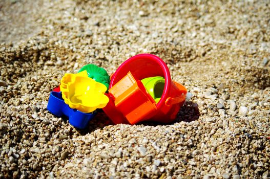 Children beach toys on the pebbles beach