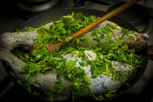 Two raw trouts in the frying pan ready to cook