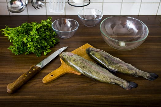 Two raw trouts on the kitchen table, ready to cook