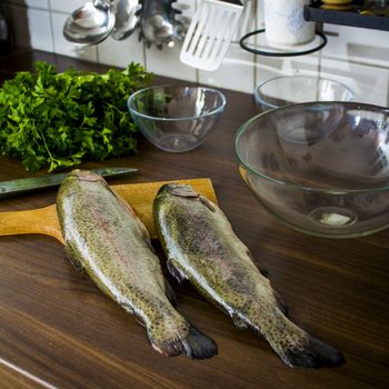 Two raw trouts on the kitchen table, ready to cook